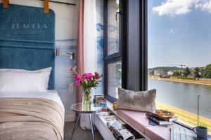a bedroom with a bed and a view of a river at Fragola Apartments Vistula View in Kraków