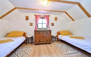 a attic room with two beds and a window at Kuća za odmor Dedino ognjište in Varaždin Breg