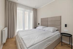 una camera da letto bianca con un letto grande e una finestra di Forest by Solarento a Międzyzdroje Altre 27 foto