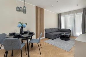 un soggiorno con un tavolo e un divano di Forest by Solarento a Międzyzdroje