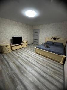 a bedroom with a bed and two dressers and a television at 1кімнатна VIP Ковпака Сумської Тероборони in Sumy