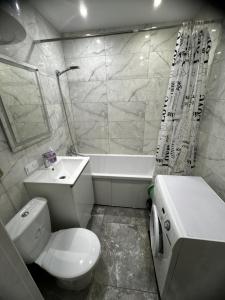 a bathroom with a toilet and a sink and a tub at 1кімнатна VIP Ковпака Сумської Тероборони in Sumy