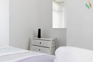 a bedroom with a bed and a dresser with a window at Thornaby Road TSAC in Stockton-on-Tees