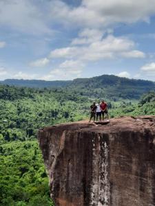 three people standing on the edge of a cliff at Red Road House in Phumĭ Bœ̆ng (1)