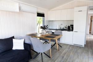 una cucina e una sala da pranzo con un tavolo e un divano di Mobile Homes Polen - Jersleber See Camping & Erlebnisresort a Jersleben