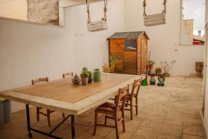 ein Holztisch in einem Raum mit Stühlen und einem Schuppen in der Unterkunft Agata 1913 in Galatina
