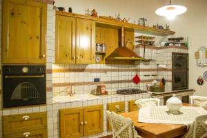 eine Küche mit Holzschränken, einem Tisch und einer Spüle in der Unterkunft Agata 1913 in Galatina