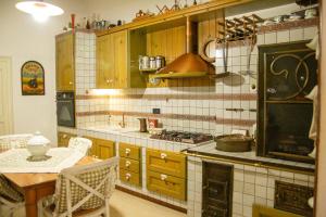 eine Küche mit Tisch und Herd Oberer Backofen in der Unterkunft Agata 1913 in Galatina + 29 Fotos