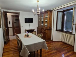 a dining room with a table and chairs and a television at L'Appartamento d'Elda in Santa Maria Maggiore