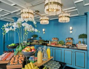 a blue kitchen with a table filled with food at The Academy - Small Luxury Hotels of the World in London +20 photos