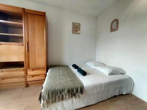 a bedroom with a bed and a wooden door at Studio Brasilia in Mont-de-Marsan