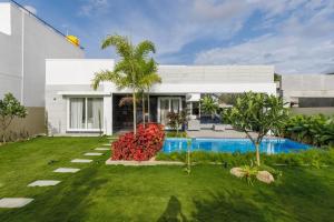 a house with a yard with a swimming pool at The Garden Stay by StayJadePool2BHKLawnAC in Berikai
