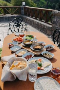 Una mesa de madera con platos de comida encima. en Lona Bungalows, en Pazar 1 foto más