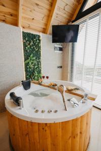 bañera de madera con lavabo en una habitación en Lona Bungalows, en Pazar