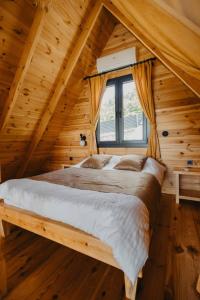 Un dormitorio con una cama grande en una cabaña de madera. en Lona Bungalows, en Pazar
