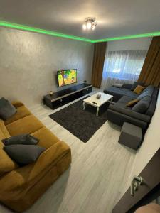 a living room with two couches and a flat screen tv at Relax Loft in Oradea