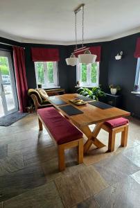 a dining room with a wooden table and a couch at Efail Y Garn in Swansea