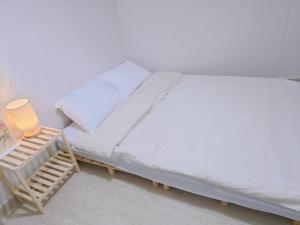 a bedroom with a bed with a night stand next to it at BusanBreeze near jagalchi Gukje Market in Busan