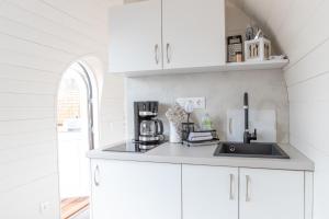 a kitchen with white cabinets and a sink at Iglus 4 Personen - Jersleber See Camping & Erlebnisresort in Jersleben