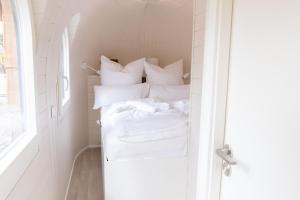 a bedroom with a bed with white sheets and pillows at Iglus 4 Personen - Jersleber See Camping & Erlebnisresort in Jersleben