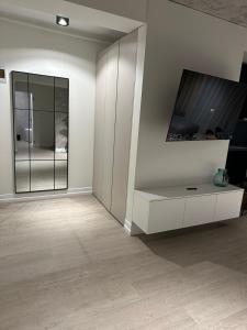 a living room with a white cabinet and a tv at Luxury Blue Apartment in Satu Mare