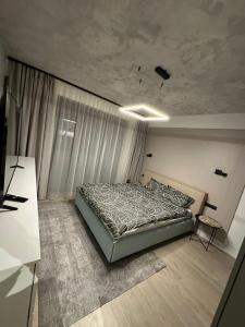 a bedroom with a bed and a desk in it at Luxury Blue Apartment in Satu Mare