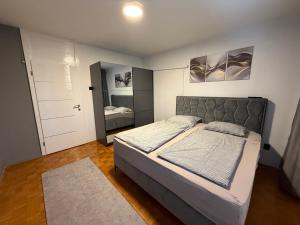 a bedroom with a large bed and a mirror at Luxury Apartment Tuzla in Tuzla