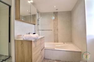 a bathroom with a tub and a sink and a bath tub at La petite salmonais in Saint Malo +21 photos