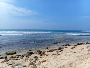 a beach with a bunch of rocks in the water at Mivin Villa - Madiha in Godakanda