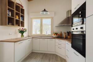 a kitchen with white cabinets and a window at Fior di Mirto in Capoterra +3 photos
