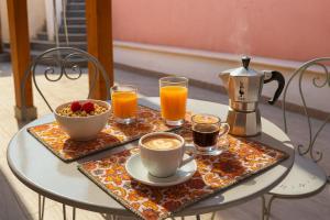 a table with two cups of coffee and a bowl of fruit at Fior di Mirto in Capoterra
