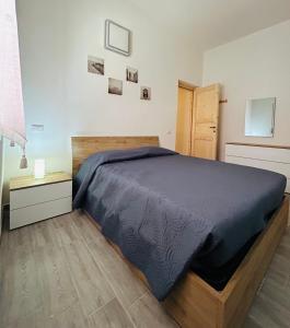 a bedroom with a bed and a wooden bed frame at Fior di Mirto in Capoterra