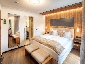 a bedroom with a large bed with a wooden wall at Mäsers Allgäuherz in Wiggensbach