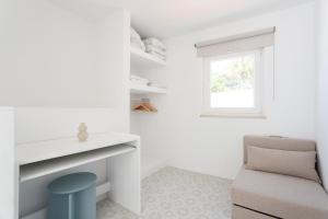 a room with a chair and a desk and a window at Alma Marina Lagos in Lagos +33 photos