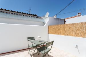 a patio with a table and chairs on a white wall at Alma Marina Lagos in Lagos