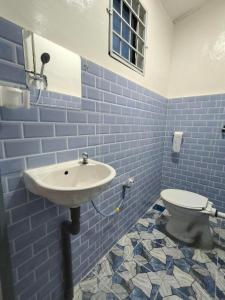 a blue tiled bathroom with a sink and a toilet at Simee 2 pax Room Stay in Gua Sai +6 photos