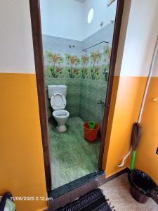 a bathroom with a toilet with a painting on the wall at Saradha paradise in Puducherry +13 photos
