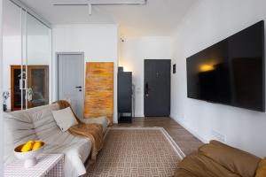 a living room with a couch and a flat screen tv at hotelise l Muse Apartment in Yerevan