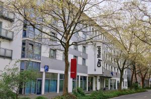 a white building with a tree in front of it at City Hotel Fortuna Reutlingen in Reutlingen