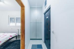a hallway with a glass door leading to a bedroom at Sreckovic Apartmani 2 in Kragujevac