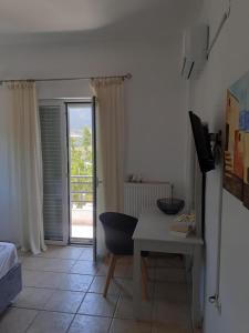 Habitación con escritorio, cama y ventana en Villa Thea, en Sísion