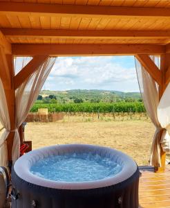 a large hot tub in a porch with a view at Le Stelle di Elisa - Wine & Truffle Glamping in Suvereto
