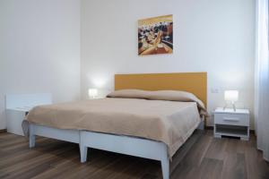 Un dormitorio con una cama y un cuadro en la pared. en Akrone Rooms City Center, en Agrigento