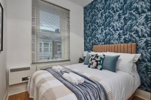 a bedroom with a large bed with a blue and white wallpaper at 4 bedroom, 6 beds, 10 guest, Free parking on site in Elswick