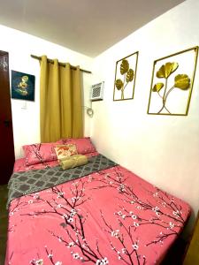 a bedroom with a bed with a red comforter at WIldFlower in General Luna +4 photos