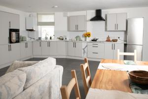 a kitchen with white cabinets and a table and a couch at Fox ford 51 in Seaton