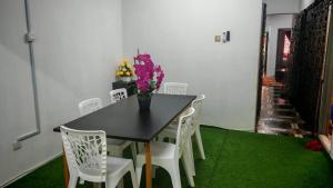 a dining room with a black table and white chairs at Homestay Kuala Lumpur in Kuala Lumpur