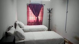 two beds in a room with a window at Homestay Kuala Lumpur in Kuala Lumpur +3 photos
