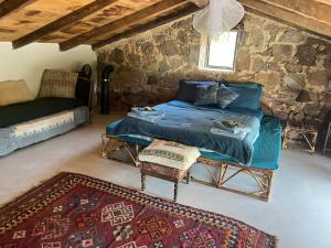 a bedroom with a bed and a couch and a rug at Maison typique Corse écologique in Coti-Chiavari