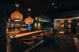 a bar in a restaurant with stools at Hotel Ecu in Genk